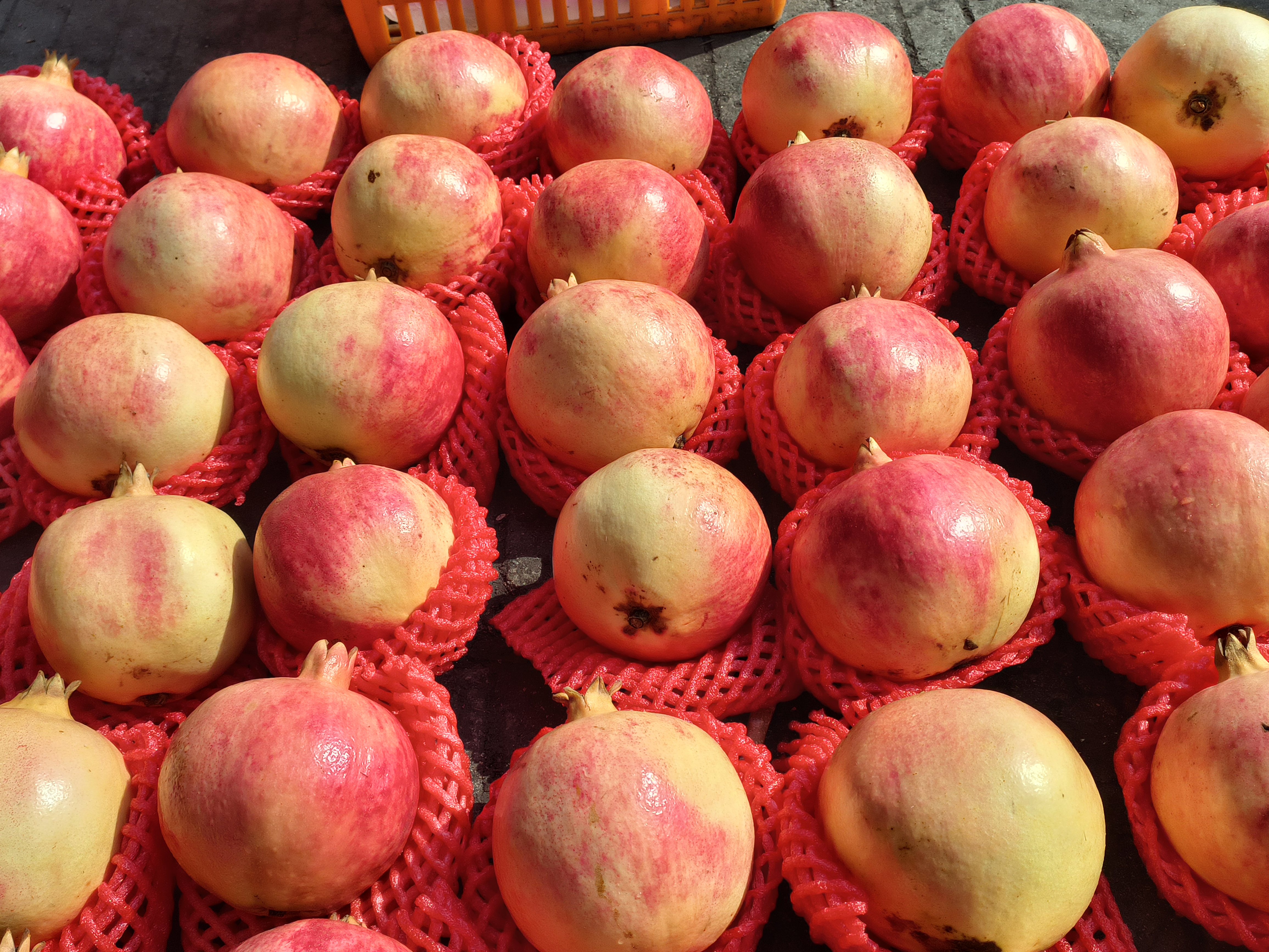 展示架上陈列着石榴酒、石榴汁、石榴果干等多种深加工产品,背景为会理本地品牌LOGO与包装设计 会理石榴深加工产品展示