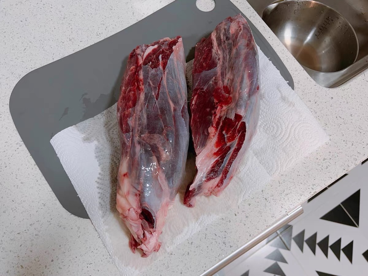 厨房案板上摆放着新鲜的黄皮洋葱和青椒,旁边有切好的食材 配图1