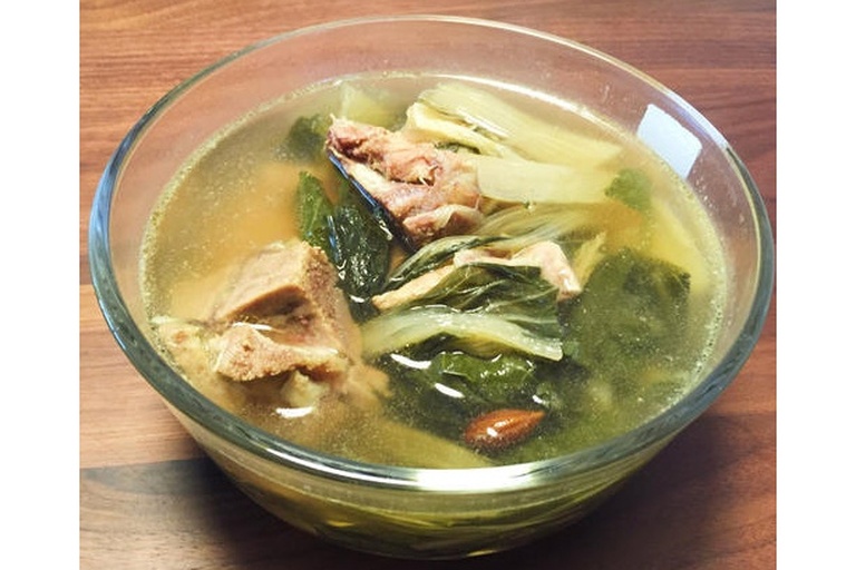 家庭厨房中正在熬制葱须白萝卜水的场景