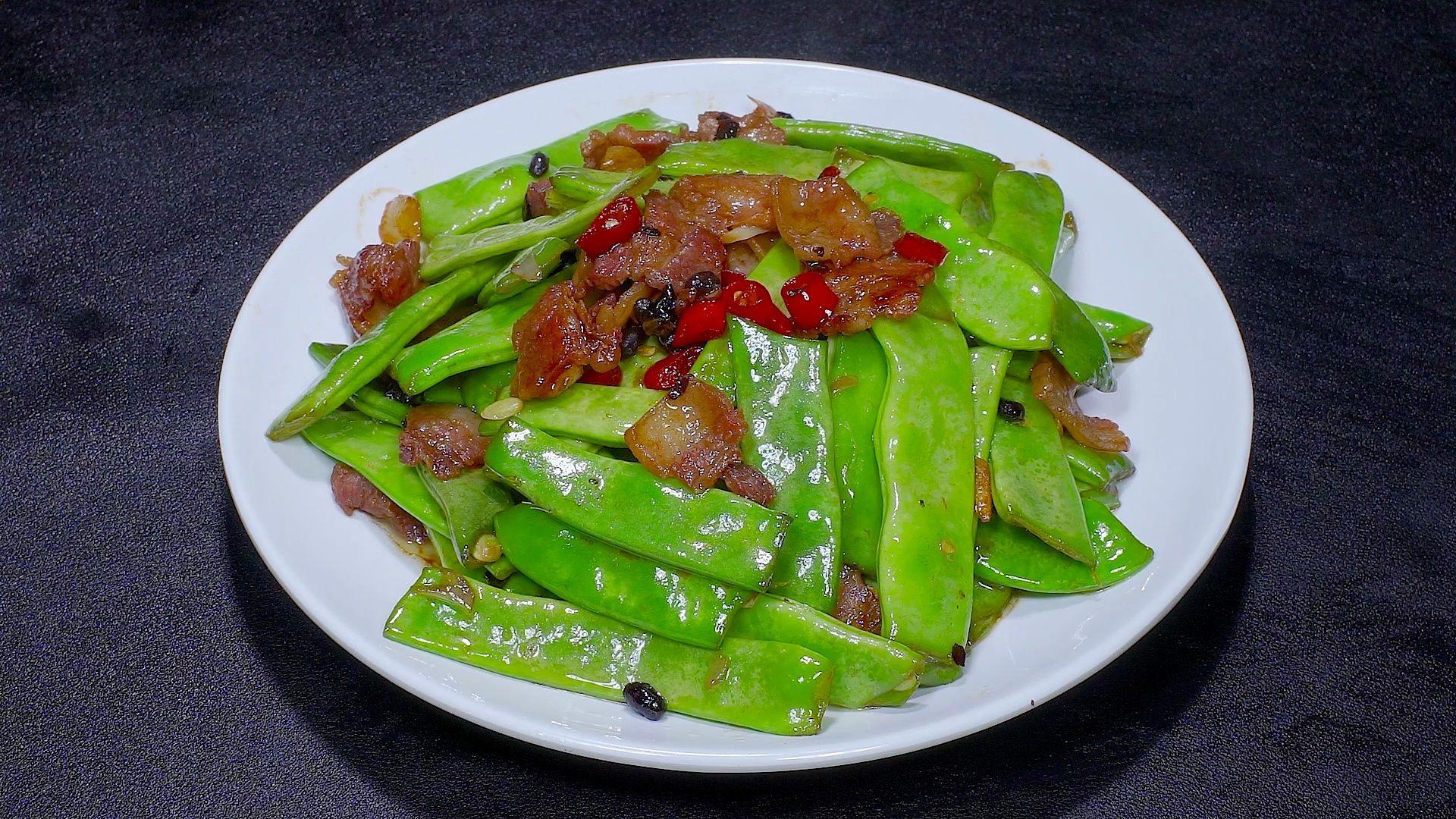 装盘的五香扁豆色泽油亮,香气扑鼻,配以米饭和筷子,准备享用 五香扁豆成品展示