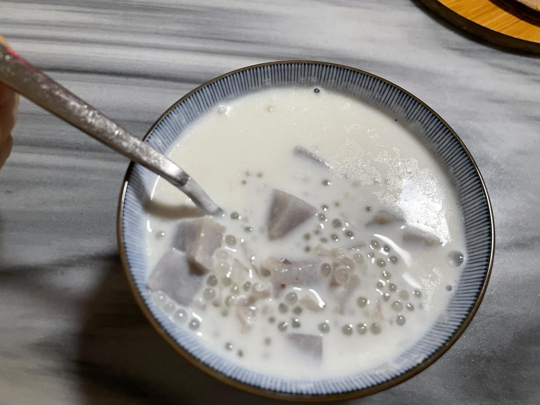 香芋西米露碗装特写：柔滑淡紫色芋泥基底上浮着晶莹Q弹西米，淋金黄桂花蜜，撒干桂花，背景虚化竹编托盘