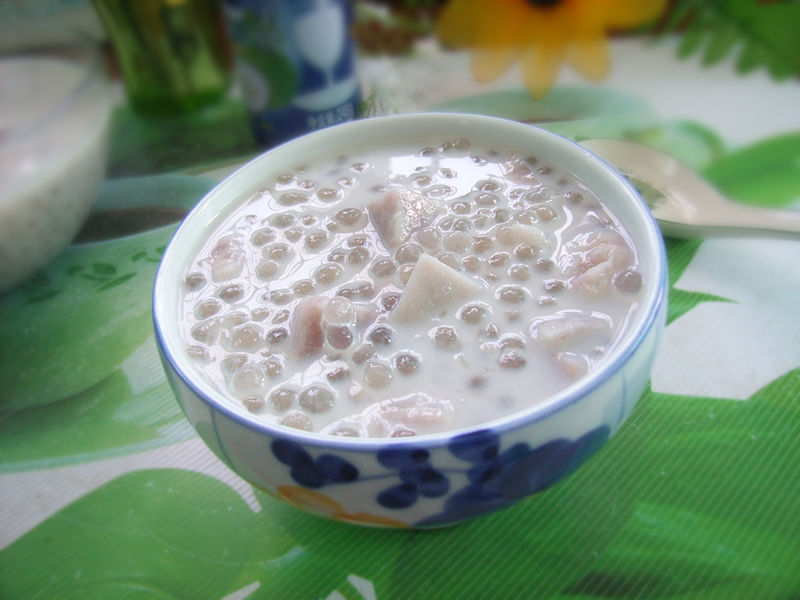 美食静物摄影:三联构图展示崇明香芋从原料到经典菜式的转化过程,突出其质地变化与色泽层次,布光柔和,背景为素色麻布纹理,强化江南饮食美学调性 崇明香芋烹饪应用对比图:左为整芋清蒸切片(晶莹微透、边缘微卷),右为香芋红烧肉成品(芋块吸饱酱汁呈琥珀色、表面油润光亮),中间摆放新鲜带皮香芋作为参照