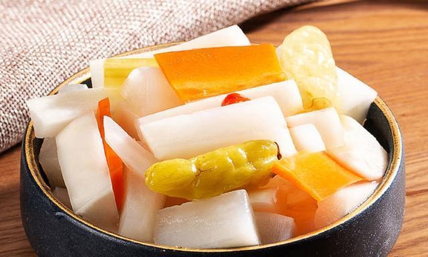 一张餐桌上摆有三道菜品:一盘刚出炉的金黄炸鸡翅,表面撒着微黑的胡椒盐颗粒;一碗热气腾腾的阳春面,上面点缀着葱花与少量黑色调料;一份白切鸡配姜葱酱,旁边小碟中可见灰白色的胡椒盐混合物。餐具为白色瓷盘,背景为浅色木纹桌面 胡椒盐应用场景