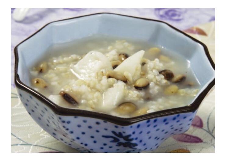 一碗热气腾腾的白不老芸豆粥,粥体浓稠,豆粒完整开花,色泽洁白柔和,旁边摆放木勺和粗陶碗,体现健康养生饮食风格 白不老芸豆烹饪成品