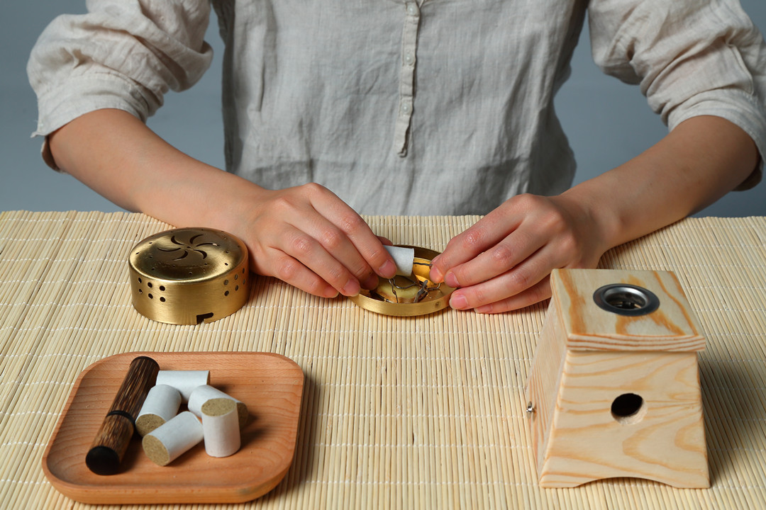 一位中医师正在使用子姜片与艾绒进行艾灸治疗,展示正确的姜疗艾灸操作流程 姜疗艾灸操作图
