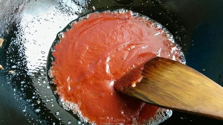 炒锅中正在翻炒平菇与菜花，食材色泽鲜亮，蒜末清晰可见，锅气升腾