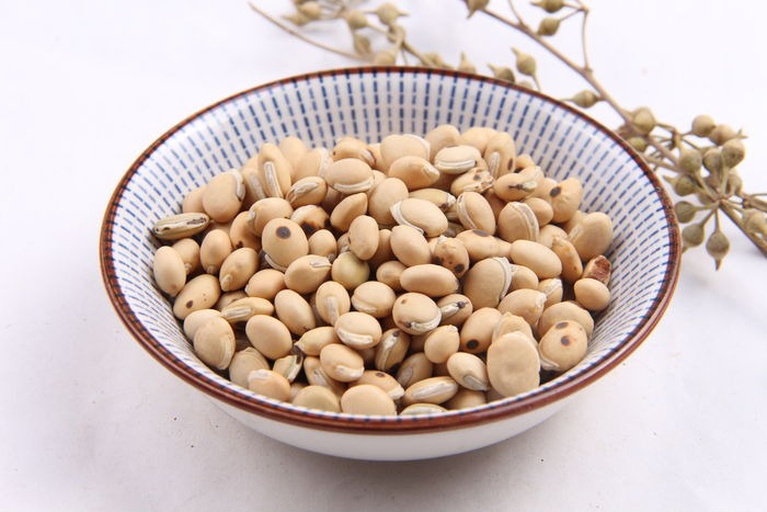 画面左侧为一杯乳白色现磨豆浆,表面有轻微泡沫;右侧为一根带刺的新鲜绿皮黄瓜,表面晶莹露珠清晰可见,背景为农家厨房木质案板 豆浆与黄瓜分开展示图