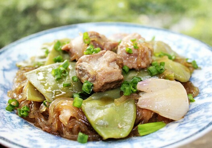 肉末滑散过程特写：冷油锅中粉红色肉末被锅铲背轻压推散，呈现均匀颗粒状，边缘微焦金黄，蒜末葱白点缀其间