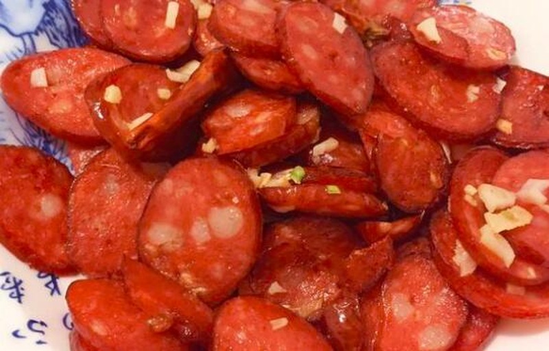 红肠切片与红蒜并列摆放,展现食材风味来源 红肠切片与红蒜并列图