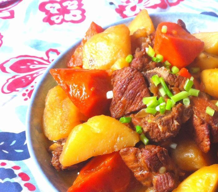 一碗刚出锅的黄花菜炖土豆,色泽红亮,土豆块软糯,黄花菜舒展,表面浮着点点油光,旁边配有白米饭和竹筷,整体呈家常温馨风格 图片描述