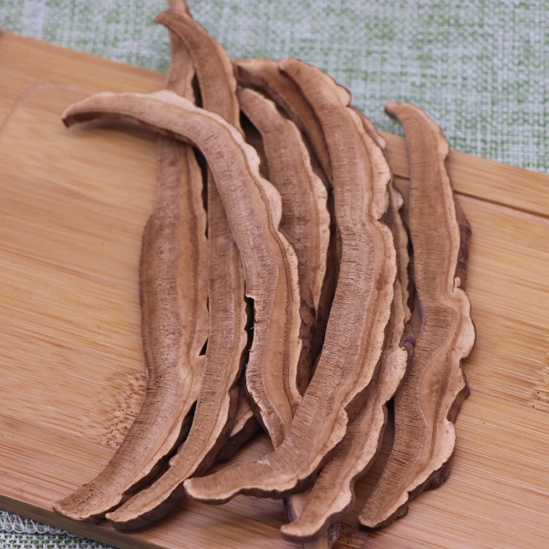 一位厨师正在将整株干灵芝放入不锈钢蒸锅中进行蒸汽软化处理,灵芝呈扇形,表面光滑有光泽,背景为厨房操作台,旁边放置有砧板和锋利的厨刀 灵芝蒸制过程