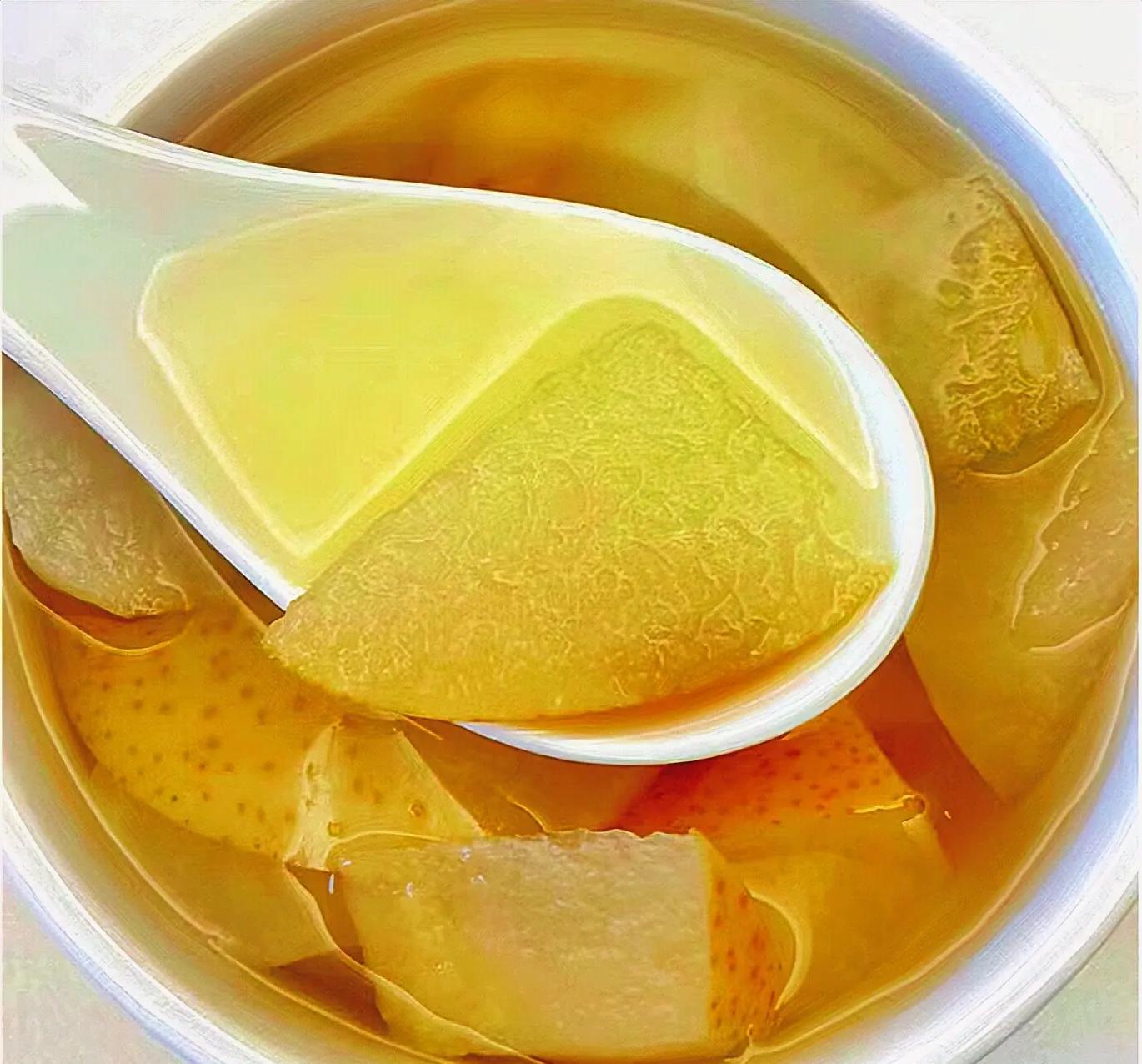 一位中年女性在家中厨房用温水冲调一勺枇杷秋梨膏于透明玻璃杯中,杯子上方有轻微热气升腾,桌面上放有标注‘有机枇杷’字样的密封罐和新鲜枇杷两颗,营造健康养生生活氛围 家庭饮用场景图