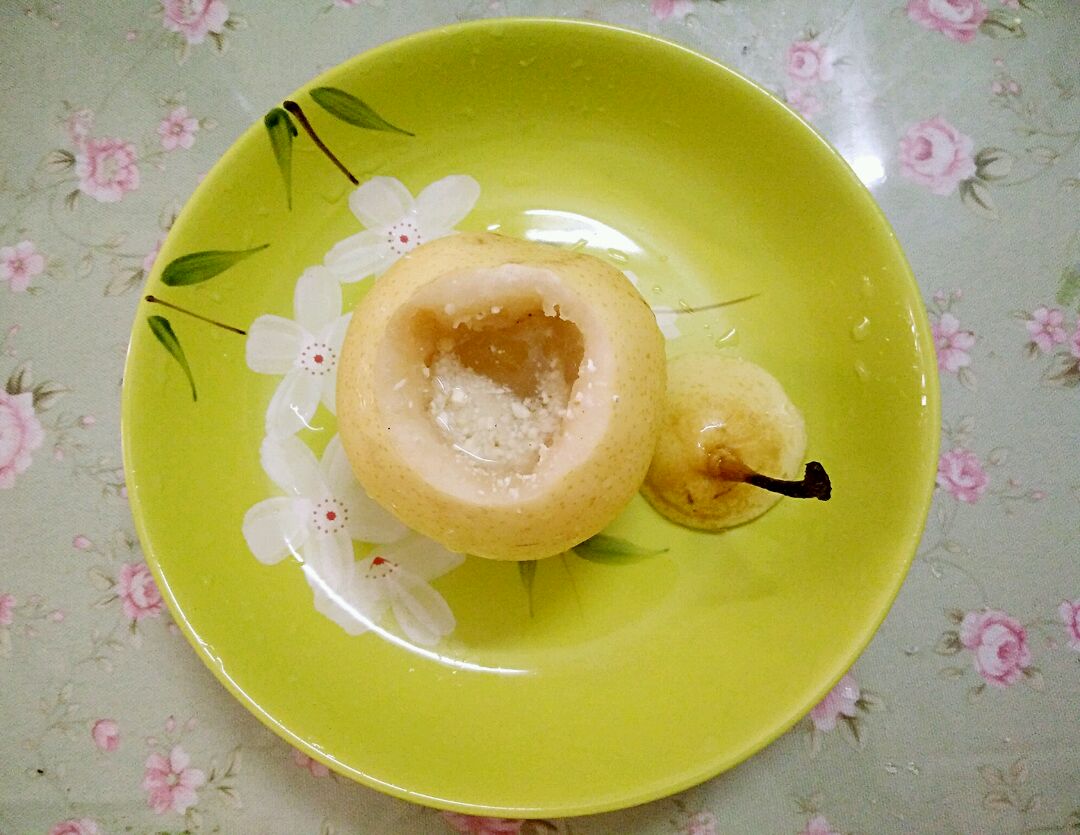 一张餐桌上的美食组合:一只盛有冰镇鞍山南果梨酒的高脚杯,旁边是一份水果奶酪拼盘和一小碗南果梨酒炖鸡汤,背景虚化中可见厨房灶台上的炖锅与南果梨原料,整体氛围温馨自然 南果梨酒美食搭配场景