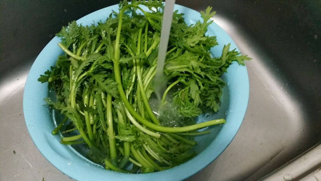 家庭厨房中清洗蔬菜的场景