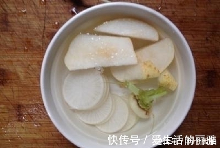 白萝卜与雪梨配伍煮水特写：陶锅中清水微沸，半块去皮白萝卜切滚刀块与两片雪梨片悬浮其中，汤色清亮微黄，表面浮有细小气泡