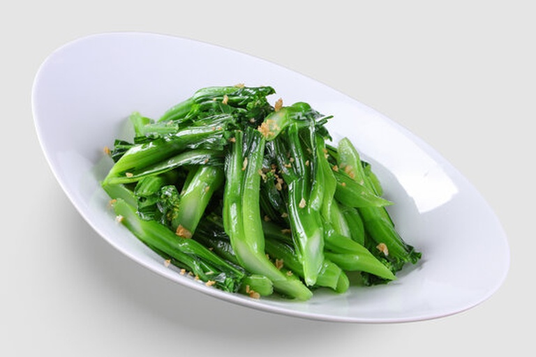 高清特写:不锈钢炒锅中油面微起涟漪,一把翠绿油麦菜竖直投入瞬间,菜叶舒展未蜷曲;锅铲正从底部向上轻翻,蒜末散落于菜叶间隙,蒸汽轻微升腾但无焦烟 油麦菜快炒过程特写