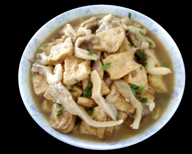 白色瓷盘中盛满炖好的蘑菇豆角土豆,色泽金黄油亮,豆角碧绿,蘑菇饱满,汤汁浓稠适中,表面浮着几点红亮油花,旁边配有米饭一碗 成品展示图