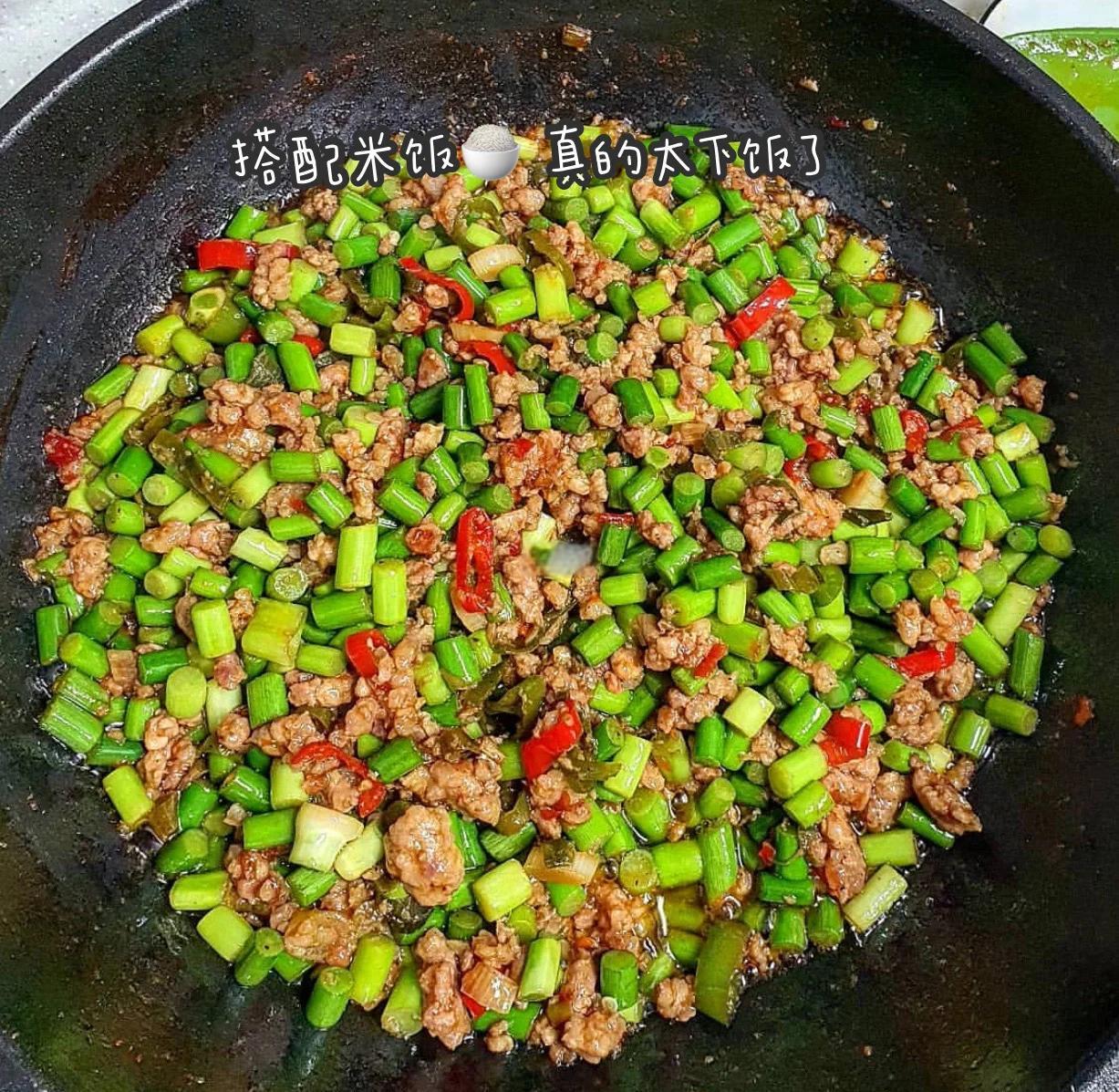 高清俯拍:青白相间的平菇条与琥珀色腊肉片交错铺陈,表面油润反光,可见清晰蒜片与翠绿葱段,背景虚化为竹制饭甑与白米饭,凸显‘下饭神器’主题 平菇炒腊肉成品特写