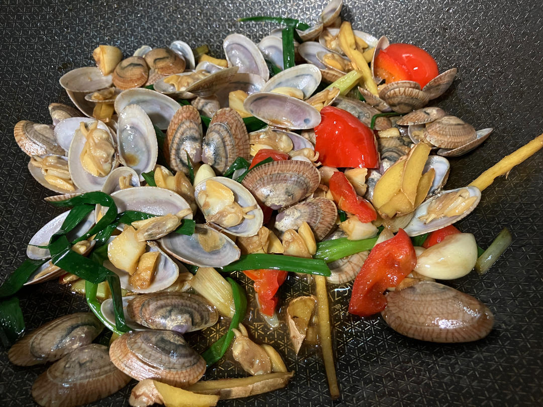 美食摄影:春季肥美花蛤经典家常做法——花蛤豆腐汤成品图,强调时令性与食用场景:汤中花蛤壳形完整、开口适度,肉质舒展饱满,汤面无浮油,整体色调清新温暖,传递‘应季而食’的健康饮食理念 俯拍全景:木质餐桌上摆放大碗花蛤豆腐汤,汤色清亮微黄,浮着几片嫩豆腐与翠绿葱花,十余只完整花蛤自然张口,露出丰腴橙白相间软体,热气袅袅上升