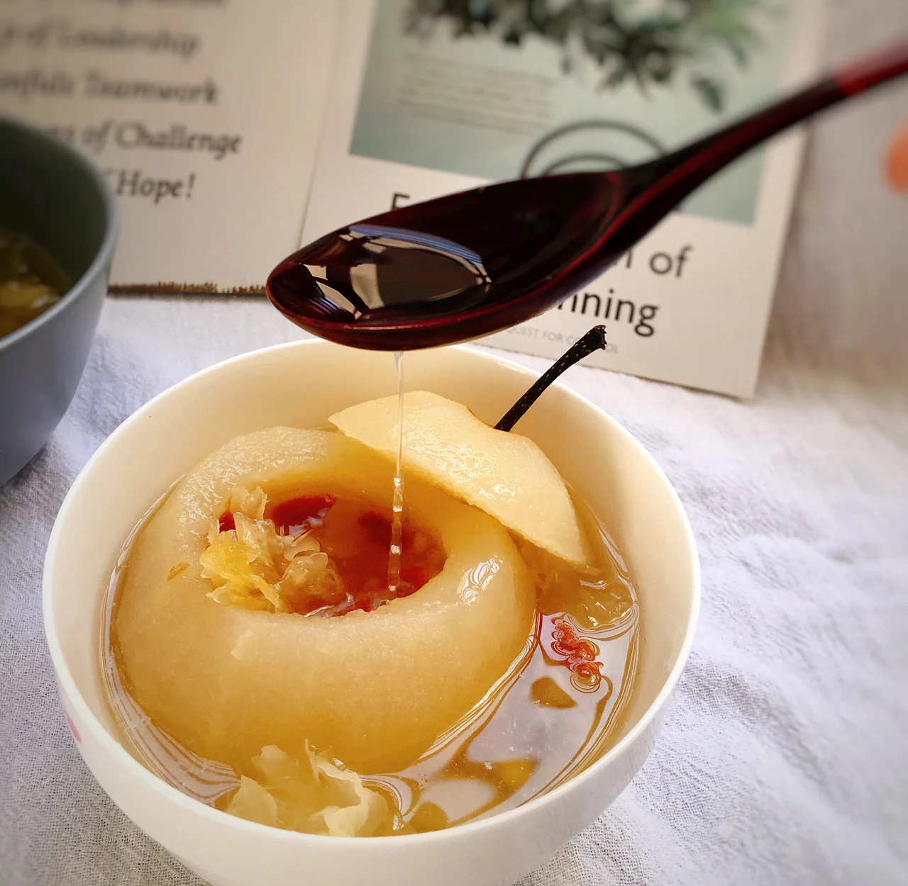 一碗热气腾腾的冰糖雪梨水,旁边摆放新鲜鸭梨 鸭梨制作的冰糖雪梨水