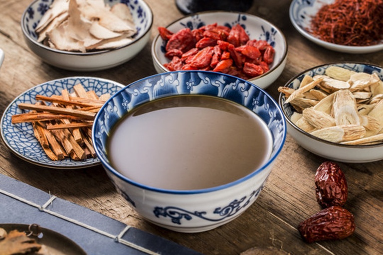 一位营养师正在向中年患者讲解饮食计划，桌上摆放多宝鱼模型与食物交换份卡片