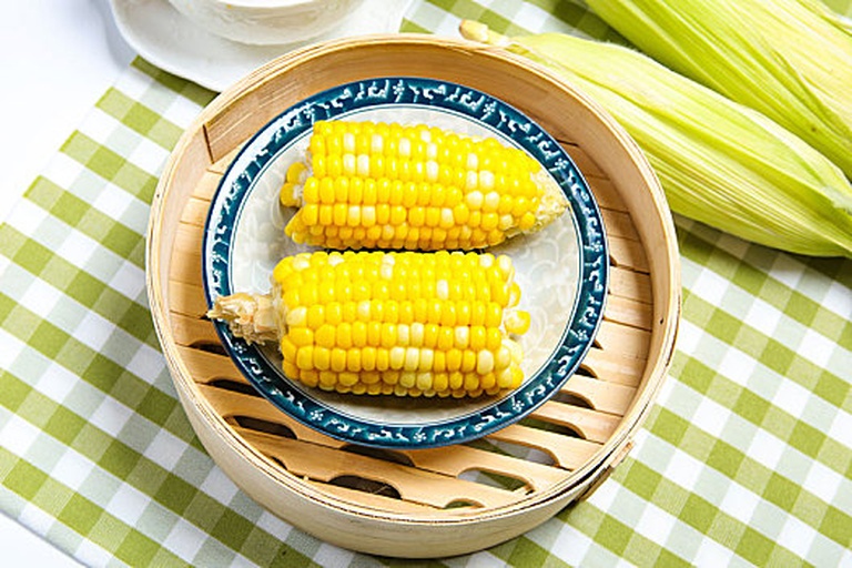 糯玉米蒸煮烹饪场景,展示其在厨房中的实用性和美味呈现方式 糯玉米烹饪场景图