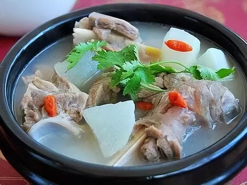 一碗热气腾腾的清炖白条羊肉汤,汤色清澈,羊肉与枸杞、红枣清晰可见,旁边摆放新鲜香菜 清炖白条羊肉汤成品图