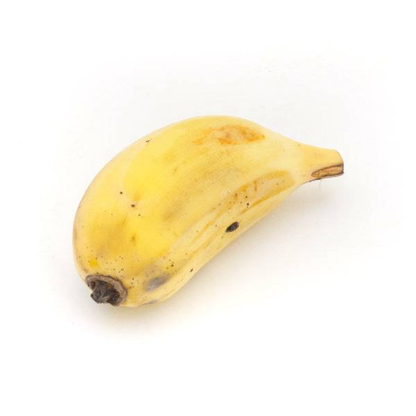 一名女性在阳光下的厨房台面上挑选放在竹篮里的成熟香蕉,香蕉表皮呈金黄色并带有自然分布的褐色小斑点,背景有模糊的绿色植物 挑选成熟香蕉