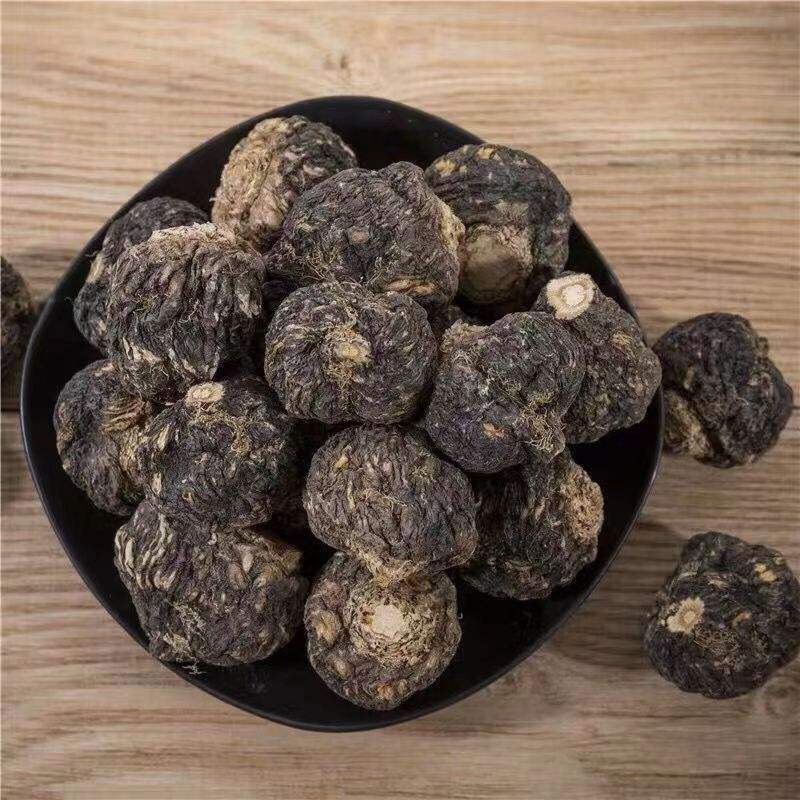 左侧为深褐色椭圆形黑玛卡干燥块根,表面有明显环状纹理;右侧为刚开壳的新鲜牡蛎,乳白色软体部分饱满,附着在灰白色贝壳内壁,背景为自然光下的厨房操作台 黑玛卡块根与新鲜牡蛎并列展示