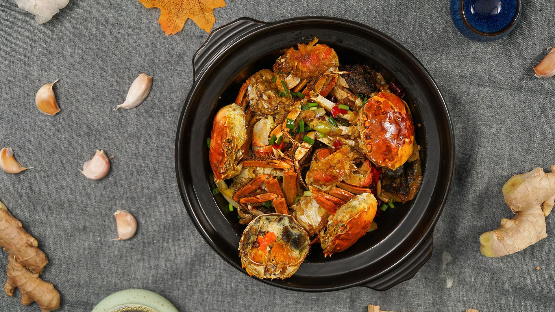 一张高清俯拍照片,展示一桌家常菜,左侧为切块的白萝卜清炖汤,右侧为蒸熟的整只大闸蟹,中间用隔板分开,象征不宜混食;背景为木质餐桌,自然光线柔和,营造温馨用餐氛围 白萝卜与螃蟹分盘摆放的餐桌实景