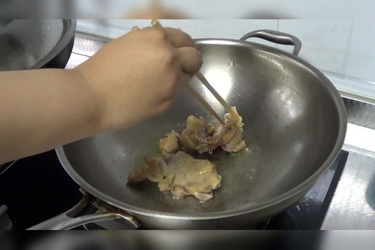 厨师正在锅中翻炒鸡腿与大葱,火候适中,香气四溢 葱爆鸡腿翻炒过程