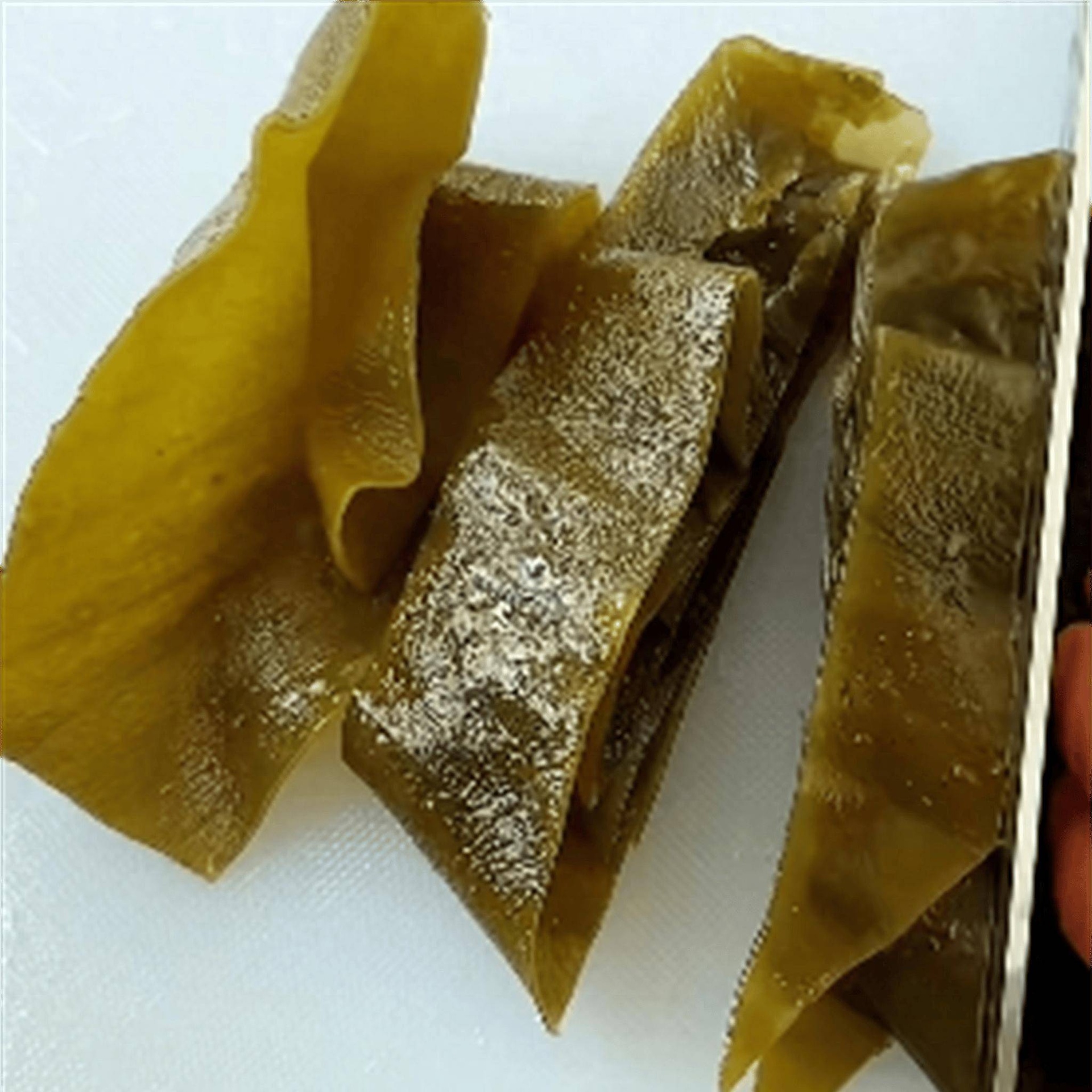 场景实拍图:专业日料厨房中昆布出汁制作过程,突出低温萃取工艺与高汤澄澈质感,体现昆布不可替代的鲜味价值 日本厨师正在用昆布制作出汁:玻璃锅中清水浸没整张墨绿色昆布,温度计显示水温55℃,旁边摆放滤纸与小瓷碗盛放清澈琥珀色高汤