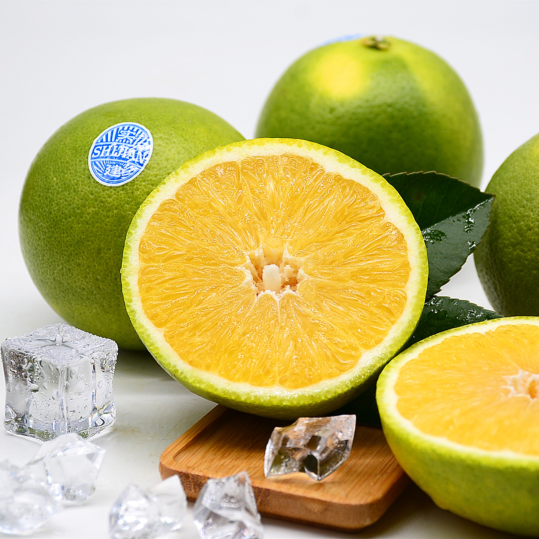 蜜橘果肉与老皮小青柑皮碎在透明玻璃碗中混合,背景为厨房料理台与阳光 蜜橘果肉与小青柑皮的搭配展示