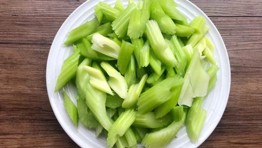 新鲜采摘的山芹被整齐摆放在木桌上准备烹饪