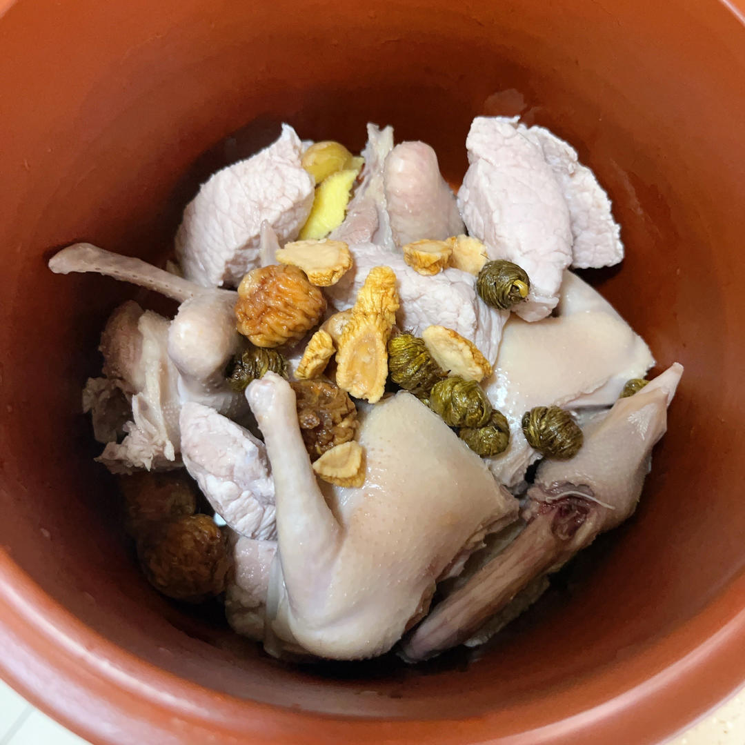 展示砂锅中正在炖煮的粉葛花胶煲鸡,汤色清澈,食材丰富 粉葛花胶煲鸡炖煮过程