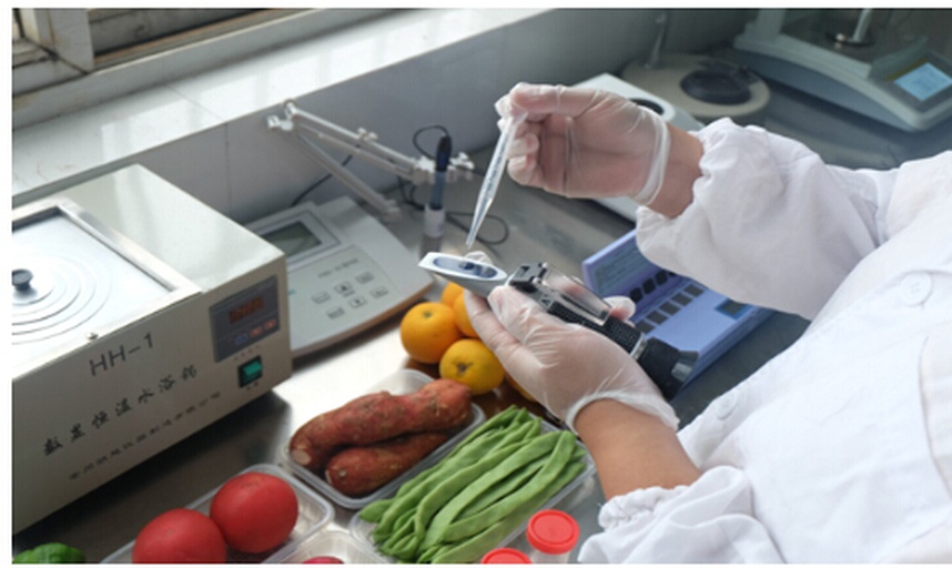 一名身穿白色实验服的科研人员正在使用高效液相色谱仪(HPLC)对柑橘类水果提取物进行分析,屏幕上显示化学成分图谱,桌上摆放着标有‘沃柑’‘葡萄柚’‘橙子’等样品瓶,背景为现代化食品检测实验室 实验室检测场景
