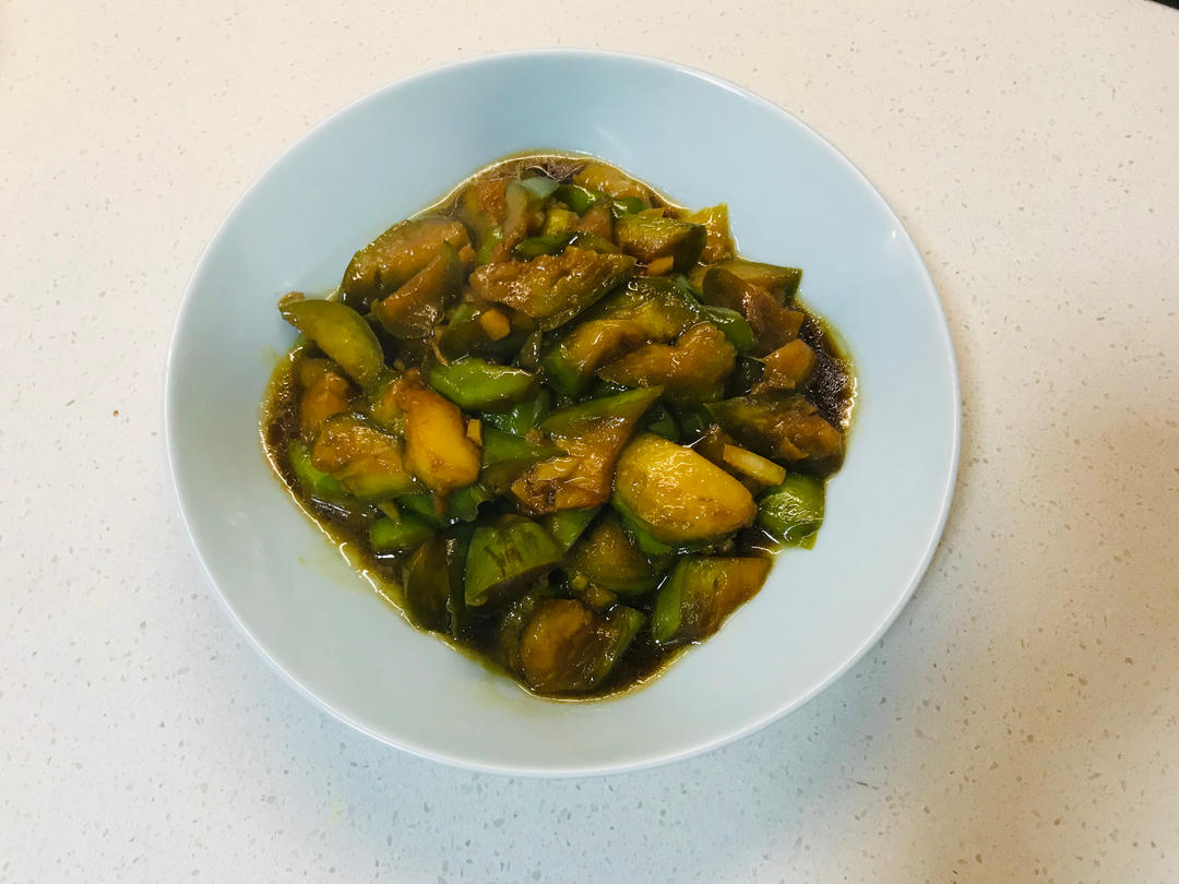 盛在盘中的青茄炒辣椒,色泽翠绿,香气四溢,诱人食欲 青茄炒辣椒成品图