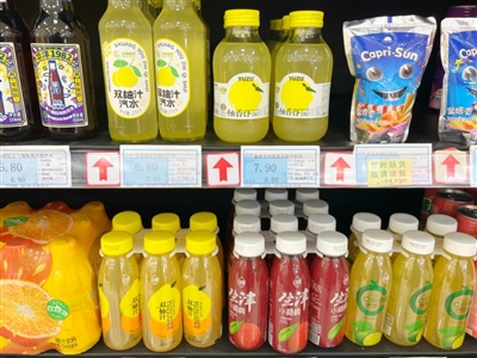 超市货架上摆放着多种品牌的葡萄柚汁产品