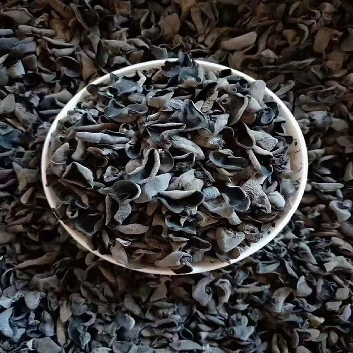 中年女性在厨房查阅药物与食物相互作用信息,展示黑木耳与抗凝类食物需谨慎搭配的场景 一位中年女性在厨房查看药品说明书,旁边放着黑木耳、纳豆和鱼油瓶,桌上摊开一份饮食注意事项清单