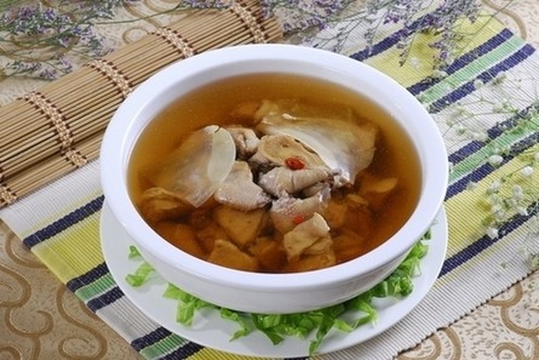 一碗刚出锅的鸡肉姬松茸汤,汤色清澈呈淡金黄色,可见大块鸡肉与厚切姬松茸片,表面漂浮少量油星与葱花,背景虚化体现温馨用餐氛围 成品鸡肉姬松茸汤盛放在白色瓷碗中,汤色清亮,鸡肉与姬松茸分布均匀,顶部撒有绿色葱花