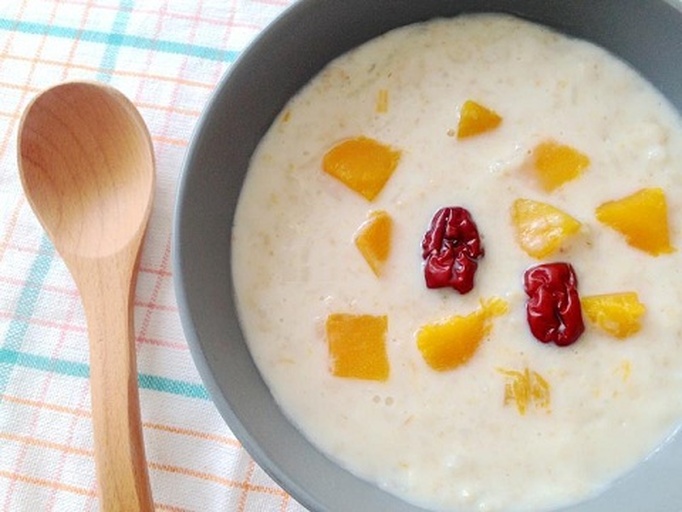 左侧为一碗热腾腾的油栗炖鸡汤,中间是一小碗油栗糯米红枣粥,右侧是精致的油栗奶油蛋糕切片,背景为秋日餐桌布置,落叶与南瓜装饰营造温馨氛围 油栗多种食用场景拼图