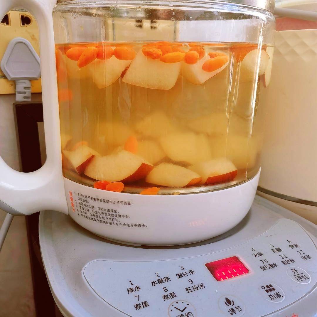 透明玻璃养生壶内正在炖煮的苹果雪梨水,汤色清亮呈浅琥珀色,苹果与雪梨块完整分明,表面有细小气泡翻滚,背景为简约中式厨房环境 玻璃养生壶中正在炖煮苹果雪梨水,液体呈琥珀色,苹果雪梨块清晰可见,上方蒸汽袅袅上升