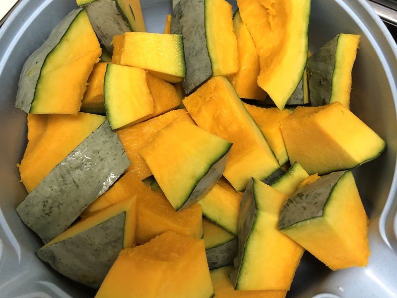 青南瓜烹饪准备图,展示切片后的食材与中式炒菜工具组合 厨房操作台上摆放着切好的青南瓜片、蒜末、红椒丝,旁边有炒锅和木铲,展示即将进行清炒的准备场景