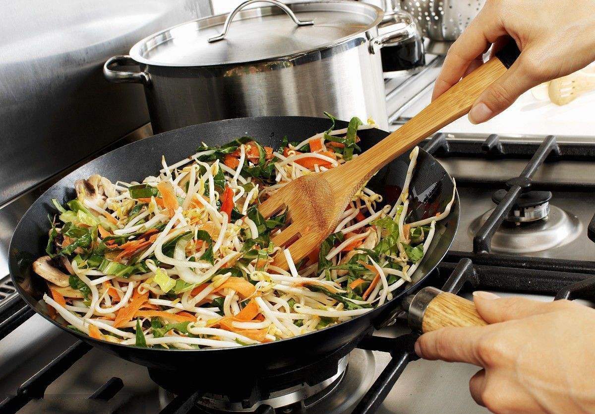 家庭厨房中正在翻炒毛豆鸡蛋的场景