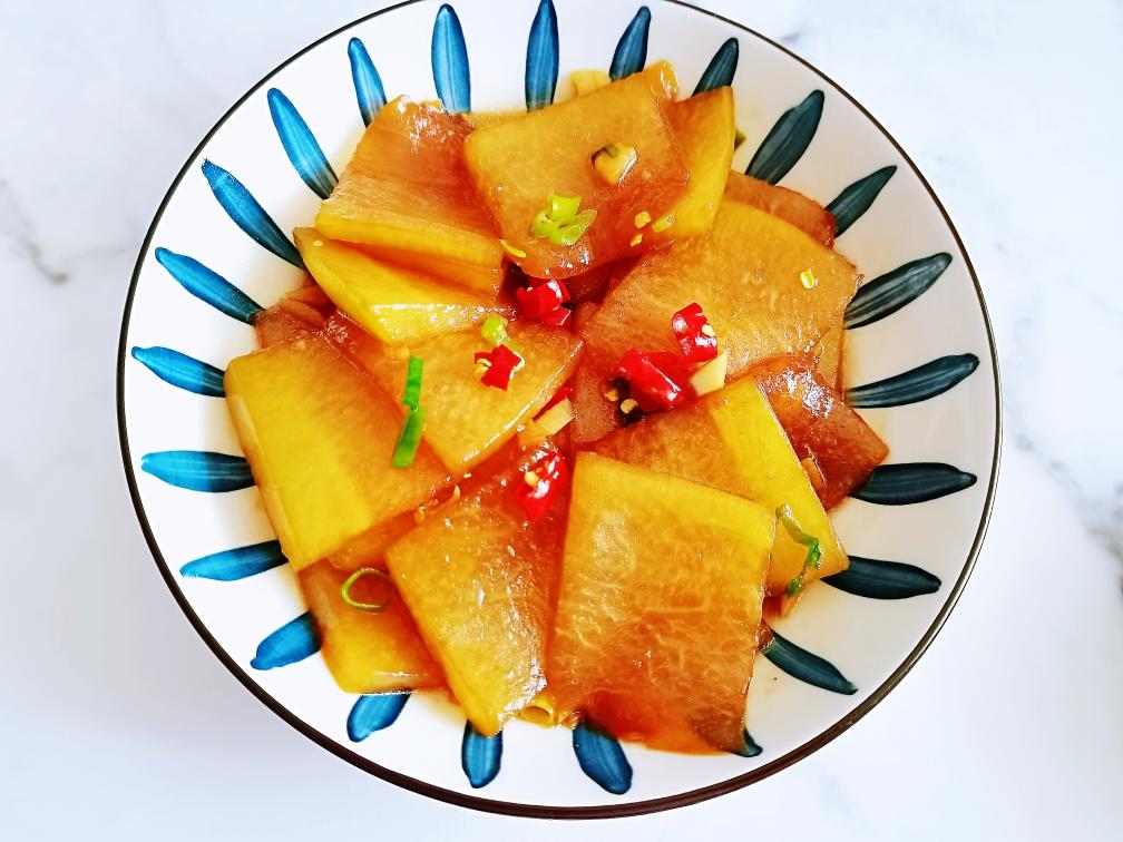 一盘刚出锅的红皮萝卜水饺,饺子皮晶莹剔透,隐约可见内部白色的萝卜丝和粉红色的肉馅,热气腾腾,旁边配有醋碟和蒜瓣 红皮萝卜水饺成品图