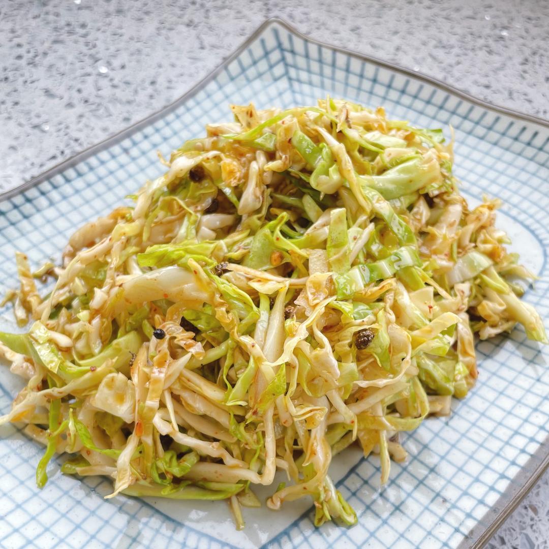 高清特写:新鲜青白圆包菜被对半切开,露出紧实淡黄叶球;手部正在沿叶脉方向自然撕成不规则大片,边缘略带毛边,案板上无碎屑,体现‘手撕保脆’工艺 圆包菜手撕处理全过程特写