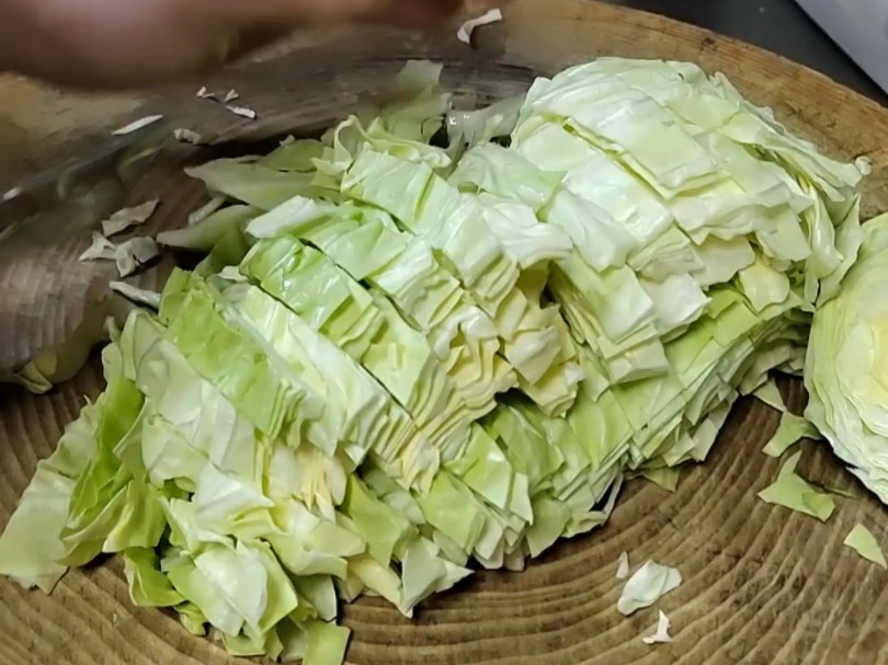 厨房案板上分别放置切开的圆白菜和圆生菜