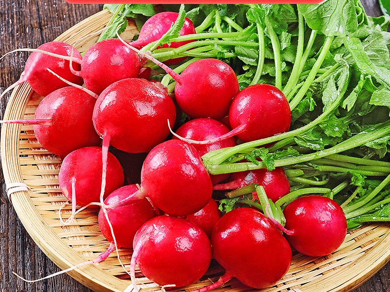 新鲜红皮萝卜堆叠在竹编篮中,表皮红润光滑,顶部带有绿色萝卜叶,背景为厨房台面 新鲜红皮萝卜堆叠在竹编篮中,表皮红润光滑,顶部带有绿色萝卜叶,背景为厨房台面