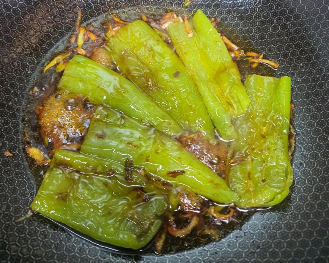 线椒在锅中煎制,表面微焦,香气四溢 线椒煎制过程图