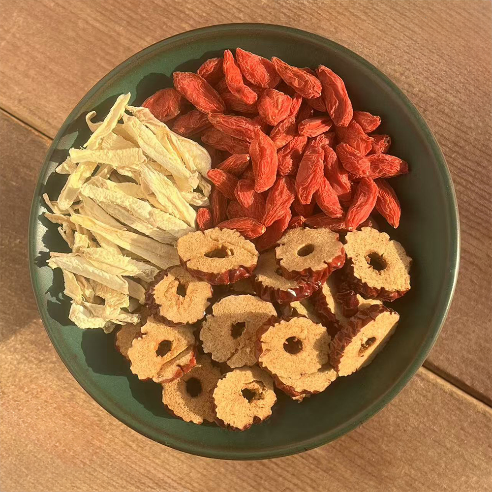 一张家庭餐桌上的健康果盘,中央摆放着洗净的新鲜长枣,周围配有核桃、枸杞、小米粥和一杯温水,旁边放置一把小勺和餐巾纸,营造出科学养生的饮食氛围 长枣餐桌搭配场景